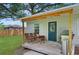 Cozy back porch area with chairs, table, grill and well-maintained yard provides relaxation and outdoor enjoyment at 832 Donnelly Pl, Daytona Beach, FL 32114