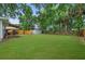 Expansive backyard featuring a green lawn, shed, and a charming, covered deck at 832 Donnelly Pl, Daytona Beach, FL 32114