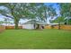 Spacious backyard with lush green lawn, wooden fence, and lovely home exterior at 832 Donnelly Pl, Daytona Beach, FL 32114