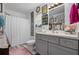 Bright bathroom featuring a shower with curtain, grey vanity, decorative walls, and stylish decor throughout at 832 Donnelly Pl, Daytona Beach, FL 32114