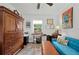 Comfortable room with a blue sofa, workspace desk, colorful rug, and a large armoire at 832 Donnelly Pl, Daytona Beach, FL 32114