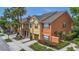 This townhome showcases a two-story exterior with a covered entrance, landscaping, and attached garage at 893 Assembly Ct, Reunion, FL 34747