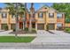Charming townhome showcasing well-maintained landscaping, attached garages, and welcoming front entrances at 893 Assembly Ct, Reunion, FL 34747