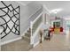 Welcoming foyer showcasing a staircase, neutral wall paint, and views into the living room at 893 Assembly Ct, Reunion, FL 34747