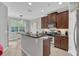 Well-equipped kitchen features dark cabinetry, modern appliances, and a breakfast bar with pendant lighting at 893 Assembly Ct, Reunion, FL 34747