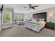 Relaxing primary bedroom suite with large windows, a cozy seating area, and neutral decor at 893 Assembly Ct, Reunion, FL 34747