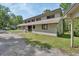 Neutral-colored house featuring a gravel driveway, simple landscaping, and a partial view of the backyard at 910 Braddock Rd, Enterprise, FL 32725
