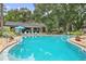 Community pool with expansive tanning deck, multiple tables, and lounging chairs for residents at 940 Douglas Ave # 189, Altamonte Springs, FL 32714