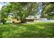 Large backyard featuring mature trees and a screened-in patio, providing ample outdoor space at 952 N Fairbairn Dr, Deltona, FL 32725