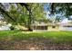 The spacious backyard features lush green grass, trees, a white fence, and a screened-in patio at 952 N Fairbairn Dr, Deltona, FL 32725