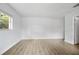 Open bedroom with wood-look floors, a window, and an entry door at 952 N Fairbairn Dr, Deltona, FL 32725