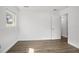 Bright bedroom featuring wood-look flooring, white walls, and an entry door at 952 N Fairbairn Dr, Deltona, FL 32725