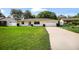 Well-maintained yellow home with an attached garage and neatly trimmed front yard at 952 N Fairbairn Dr, Deltona, FL 32725