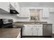 Cozy kitchen features stainless steel appliances, white cabinets, and wood-look flooring at 952 N Fairbairn Dr, Deltona, FL 32725