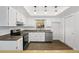 Well-lit kitchen featuring white cabinets, stainless steel appliances, and wood floors at 952 N Fairbairn Dr, Deltona, FL 32725