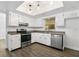 Sunlit kitchen features stainless steel appliances, white cabinets, and wood-look flooring at 952 N Fairbairn Dr, Deltona, FL 32725