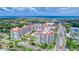 Wide aerial perspective of a red-roofed condo building surrounded by palm trees and coastal scenery at 1 John Anderson Dr # 3170, Ormond Beach, FL 32176