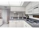 Well-lit kitchen features white cabinets, granite countertops, modern appliances, and a view to the dining area at 1 John Anderson Dr # 3170, Ormond Beach, FL 32176