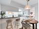 Bright kitchen featuring a breakfast bar with seating, white cabinets and view to the living area at 1 John Anderson Dr # 3170, Ormond Beach, FL 32176
