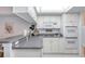 Well-lit kitchen features white cabinets, granite countertops, modern appliances, and a geometric ceiling fixture at 1 John Anderson Dr # 3170, Ormond Beach, FL 32176