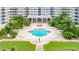 Aerial view of a clover-shaped pool surrounded by lounge chairs, palm trees, and perfectly manicured lawn at 1 John Anderson Dr # 3170, Ormond Beach, FL 32176