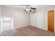 Bright bedroom featuring carpet, ceiling fan, closet, and an open loft area at 101 N Hill Ave # 6, Deland, FL 32724