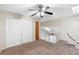Spacious carpeted bedroom with a ceiling fan, closet, and railing overlooking the floor below at 101 N Hill Ave # 6, Deland, FL 32724