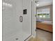 Bathroom featuring tiled shower with glass door that leads to a bedroom with a ceiling fan at 1018 River Falls Cir, Deland, FL 32720