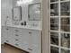 Bathroom with double vanity, updated fixtures, and a large linen closet with see-through shelving at 1018 River Falls Cir, Deland, FL 32720