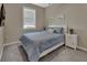 Well lit bedroom with a window, night stands, lamps, and art hung over the bed at 1018 River Falls Cir, Deland, FL 32720