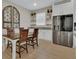 Cozy dining area with natural light, open shelving, and stainless steel refrigerator at 1018 River Falls Cir, Deland, FL 32720