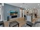 Stylish living room area with blue accent wall open to kitchen and dining, featuring wood-look flooring at 1018 River Falls Cir, Deland, FL 32720