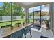 Screened in patio with a table and chairs overlooking a manicured backyard at 1018 River Falls Cir, Deland, FL 32720
