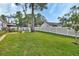Large, green backyard enclosed by a white fence with ample space for recreation and gardening at 1020 N Orange Ave, Orange City, FL 32763