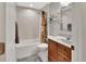 Bright bathroom featuring a shower-tub combo, neutral tile, and vanity with storage at 1020 N Orange Ave, Orange City, FL 32763