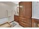 Bathroom featuring wood cabinetry, vanity, glass shower, and updated fixtures at 1020 N Orange Ave, Orange City, FL 32763