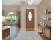 Bright entry foyer featuring tile flooring, arched window, and decorative front door at 1020 N Orange Ave, Orange City, FL 32763