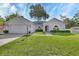 Charming single-story home with manicured lawn and mature shade tree at 1020 N Orange Ave, Orange City, FL 32763