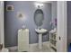Cozy bathroom with a pedestal sink, tiled floor and white cabinets for storage at 1020 Orange Camp Rd, Deland, FL 32724