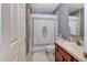 Bathroom featuring a single sink vanity, neutral walls, white door, and a decorative shower curtain at 1020 Orange Camp Rd, Deland, FL 32724