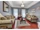 Living room with plush seating, hardwood floors, recessed ceiling and decorative chandelier at 1020 Orange Camp Rd, Deland, FL 32724