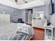 Main bedroom with cherry floors, large dresser, walk-in closet, and a large flat screen television at 1020 Orange Camp Rd, Deland, FL 32724