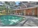 A backyard pool view features seating, brick home and outdoor kitchen, great for entertaining at 1020 Orange Camp Rd, Deland, FL 32724