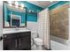 Bright bathroom with a modern vanity, stylish tile shower, and vibrant blue accent wall at 10460 Burrows St, Orlando, FL 32832