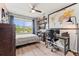Well-lit bedroom featuring a large window with scenic views, ceiling fan, and workspace at 10460 Burrows St, Orlando, FL 32832