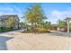 Expansive community space featuring a large tree, lush landscaping and benches for relaxing at 10460 Burrows St, Orlando, FL 32832