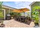 Outdoor patio with umbrella, dining table set, grill and assorted potted plants and brick pavers at 10460 Burrows St, Orlando, FL 32832