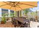 Inviting outdoor patio with a dining table under a large umbrella, surrounded by lush greenery at 10460 Burrows St, Orlando, FL 32832