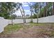 Spacious backyard with a white fence and a cinder block fire pit under a mix of sun and shade at 1094 Lolita St, Orange City, FL 32763