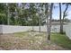Large backyard with a white fence and a cinder block fire pit under a mix of sun and shade at 1094 Lolita St, Orange City, FL 32763